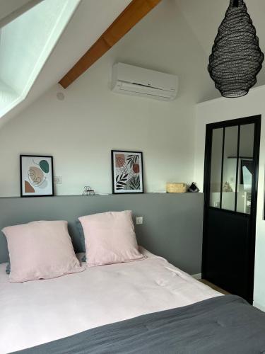 a bedroom with a bed with two pink pillows at La Paulerie in Wacquinghen