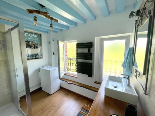 baño con lavabo y aseo y ventana en Le Clos du Val à Loup en Bénarville