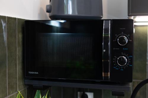 a microwave oven sitting on top of a wall at FLATMORE Apartament Akacjowa 17m1B in Zielona Góra