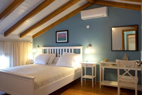 1 dormitorio con cama, escritorio y espejo en Ivi Villa, en Sivota
