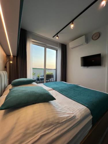 a bedroom with two beds and a large window at Apartament Fredry 2 PREMIUM KLIMA in Kołobrzeg