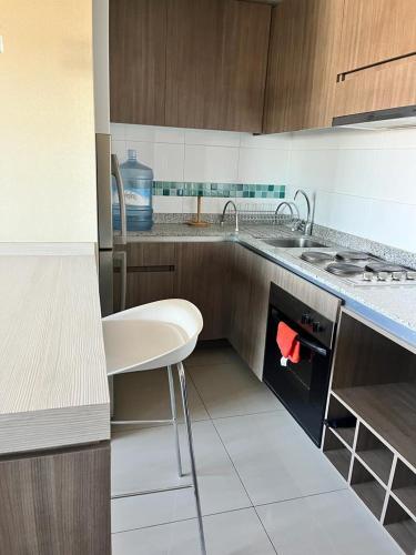a kitchen with a white chair and a sink at Edificio Concepto in Calama