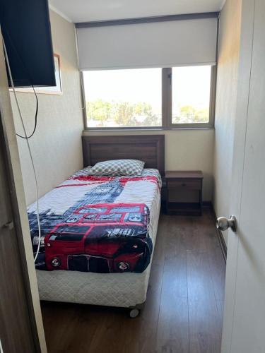 una camera con un letto con una trapunta per auto sopra di Edificio Concepto a Calama