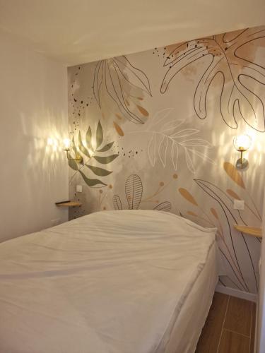 - une chambre avec un lit blanc et un mur fleuri dans l'établissement Appart 2 chambres Piscine chez ROX - Résidence du Golf, à Deauville