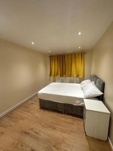 um quarto com uma cama grande e uma janela em 2BR Flat near Central Southall em Southall