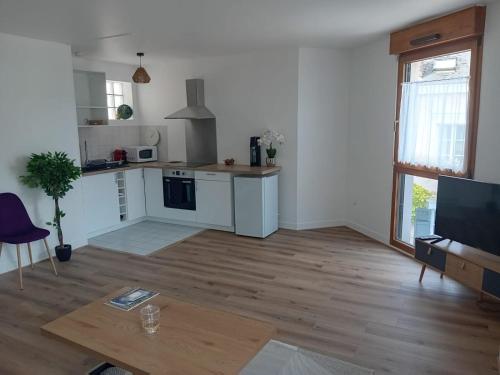 un salon vide avec une cuisine et une table dans l'établissement L'EDEN DE CHARTRES, à Chartres