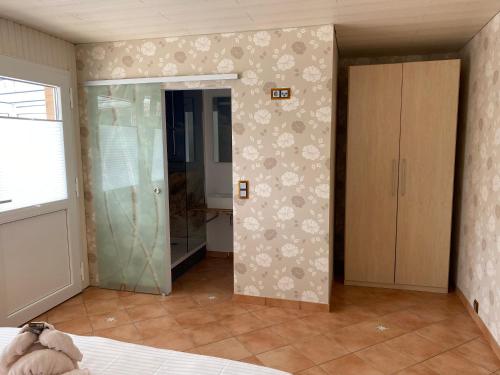a bedroom with a closet and a glass door at Hotel Meereswoge in Cuxhaven