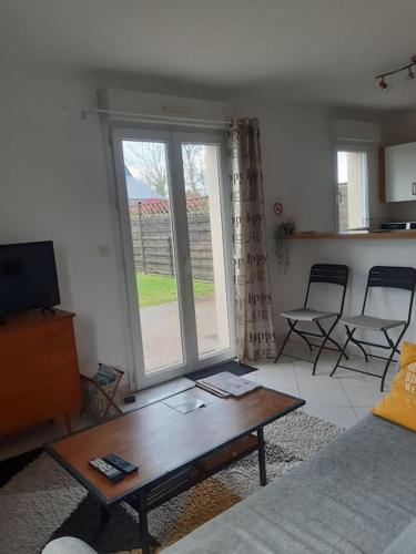 un salon avec un canapé et une table basse dans l'établissement Appartement au RDC avec jardin clos, au calme., à Saint-Aubin-du-Cormier
