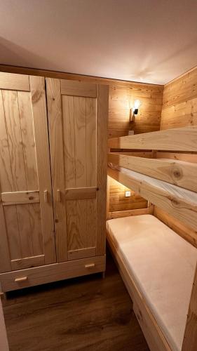 Cette petite chambre comprend 2 lits superposés et des armoires. dans l'établissement Appartement T2 6 personnes vue sur l’Eyssina, à Vars
