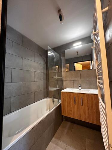 bagno con vasca bianca e lavandino di Appartement T2 6 personnes vue sur l’Eyssina a Vars