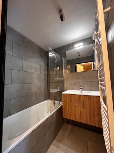 une salle de bain avec une baignoire blanche et un lavabo dans l'établissement Appartement T2 6 personnes vue sur l’Eyssina, à Vars