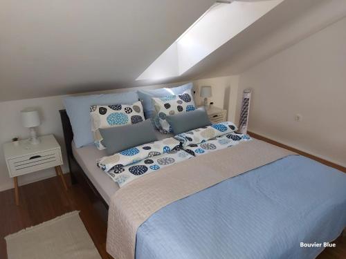 a bedroom with a bed with blue and white pillows at Apartments Bouvier in Pag