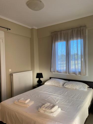 a bedroom with a bed with two towels on it at Vasilia in Nea Irakleia