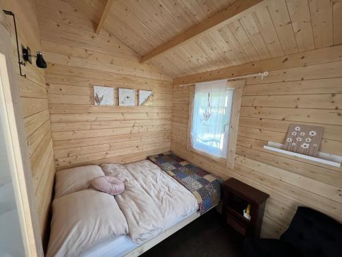 a bed in the corner of a log cabin at Mark VI Mirotki 12 ImWald Bory Tucholskie in Skórcz