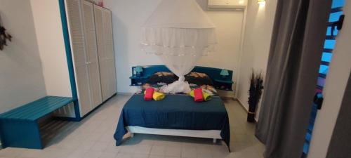 a bedroom with a blue bed with a blue comforter at TOUMALACAÏ Appart 238 in Folle Anse