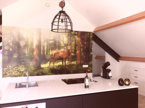 een keuken met een schilderij van een hert op de muur bij Boerderij appartement De Casterie in Bornerbroek