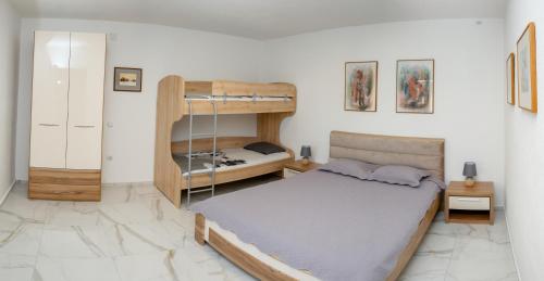 a bedroom with a bed and a bunk bed at Reshkov Pool Apartments in Gevgelija