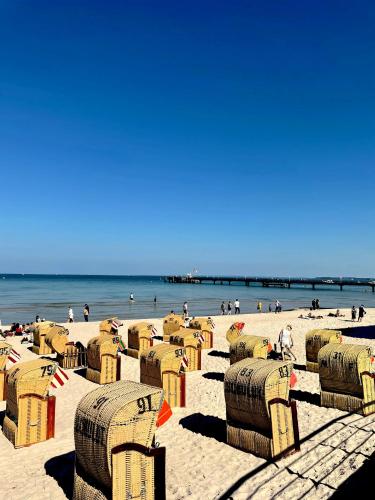a beach with many chairs and people on the beach at Modernes Apartment an Timmendorfer Promenade, 1. Reihe in Timmendorfer Strand