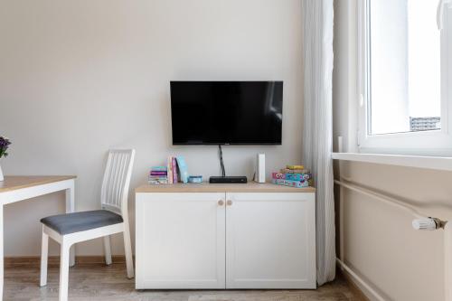 Habitación con escritorio, TV y silla. en INITIUM rooms - Apartament - Tysiąclecia 23B en Gdansk