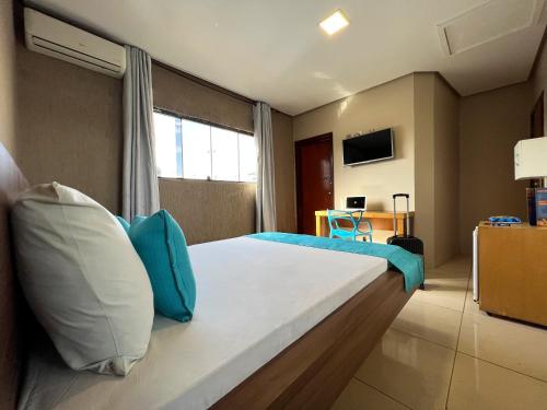 um quarto com uma cama com almofadas azuis e brancas em Dok Brasília Hotel Unidade Águas Claras em Taguatinga