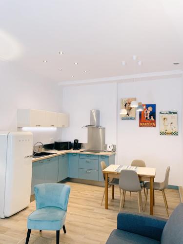 une cuisine avec des armoires bleues et une table et des chaises dans l'établissement Au cœur du vieil Antibes, à Antibes