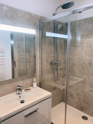 une salle de bain avec une douche en verre et un lavabo dans l'établissement Au cœur du vieil Antibes, à Antibes