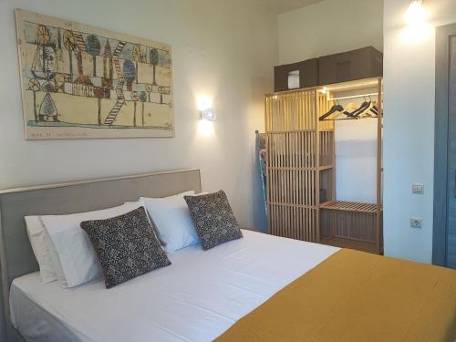 una camera con un letto bianco con due cuscini di Coritos holiday apartments a Kontokali