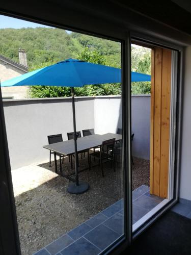 a table with an umbrella on a patio at Gîte des quatre saisons in Thilay