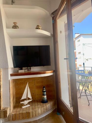 a room with a tv and a toy boat on the floor at Calella centro in Calella de Palafrugell