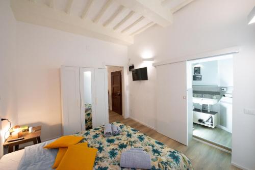 ein weißes Schlafzimmer mit einem Bett und einem Schreibtisch in der Unterkunft PINTURICCHIO Guest House in Perugia