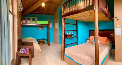 1 dormitorio con 2 literas y sofá en La Buena Vida Hotel, en Ayampe