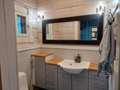 a bathroom with a sink and a mirror at Villa Mustalahti in Mikkeli