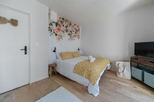 a bedroom with a bed and a flat screen tv at Résidence Aristide Briand - Appartements en Centre Ville in Vichy