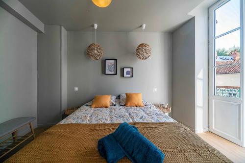 a bedroom with a large bed with orange pillows at Résidence Aristide Briand - Appartements en Centre Ville in Vichy