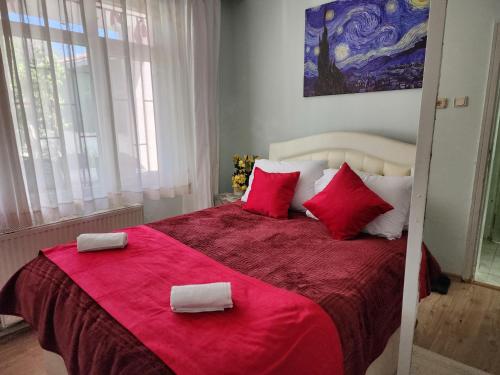 um quarto com uma grande cama vermelha com almofadas vermelhas em Two Bedroom Flat in the Garden at the Bosphorus em Istambul