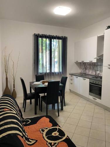 una cucina e una sala da pranzo con tavolo e sedie di Ampio appartamento in posizione strategica a Rimini