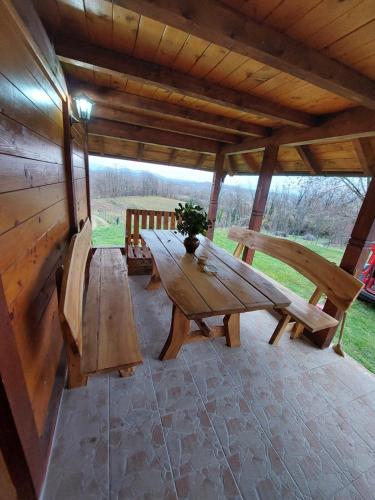 a wooden picnic table and benches in a pavilion at Kuća za odmor Filipović in Gornji Milanovac