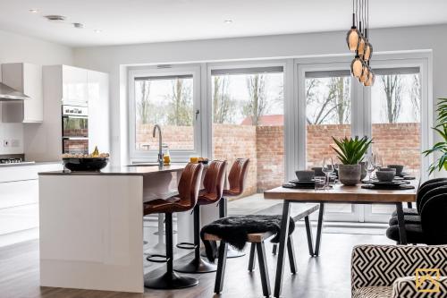 a kitchen and dining room with a table and chairs at Outstanding 5 Bedroom Townhouse, Canal Views By Valore Property Services in Milton Keynes