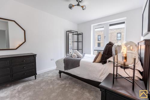 a bedroom with a bed and a mirror and a dresser at Outstanding 5 Bedroom Townhouse, Canal Views By Valore Property Services in Milton Keynes