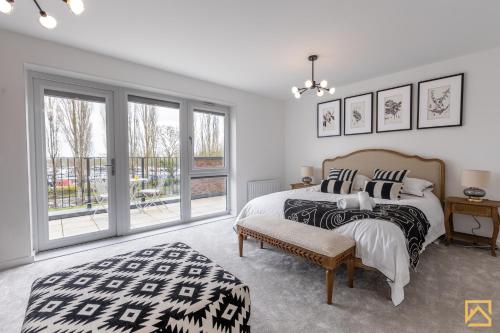 ミルトン・キーンズにあるOutstanding 5 Bedroom Townhouse, Canal Views By Valore Property Servicesのベッドと大きな窓のある寝室