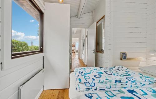 Schlafzimmer mit einem Bett und einem Fenster in der Unterkunft Beach Front Home In Rnne With Wifi in Rønne