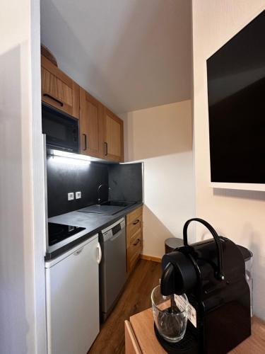 una piccola cucina con piano cottura e frigorifero di Appartement T2 6 personnes vue sur l’Eyssina a Vars