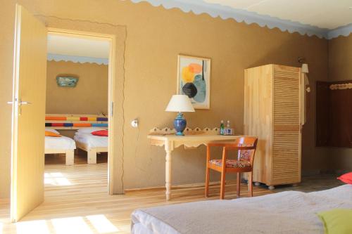 a bedroom with a desk and a room with two beds at Szwajcaria Mazurska in Zawady