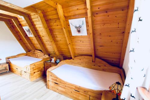a room with two beds in a log cabin at Flügels ReBi-Baude in Rechenberg-Bienenmühle
