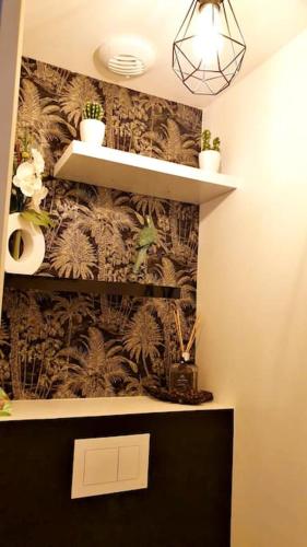 a bathroom with a wall with plants and shelves at Maison de Vacances Familiale à 15 minutes de Saint-Malo in Miniac-Morvan