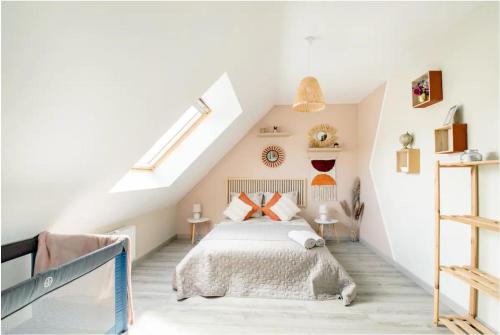 a bedroom with a bed in a attic at Maison de Vacances Familiale à 15 minutes de Saint-Malo in Miniac-Morvan