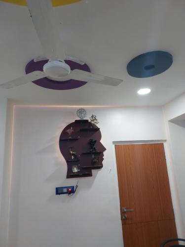 a room with a ceiling fan and a head on the wall at Hotel Sai Dakshina Inn & The Fern Restaurant in Shirdi