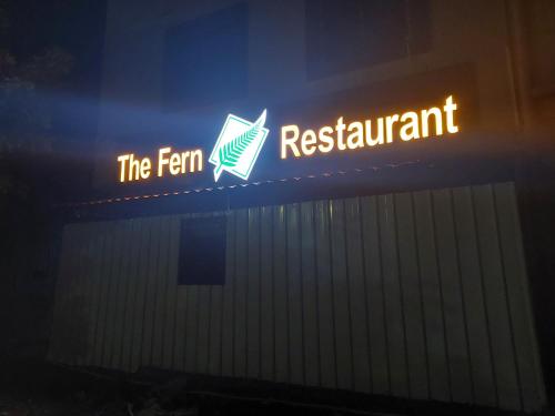 a sign for the farm restaurant on the side of a building at Hotel Sai Dakshina Inn & The Fern Restaurant in Shirdi