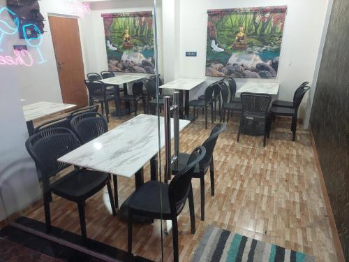 a row of tables and chairs in a restaurant at Hotel Sai Dakshina Inn & The Fern Restaurant in Shirdi