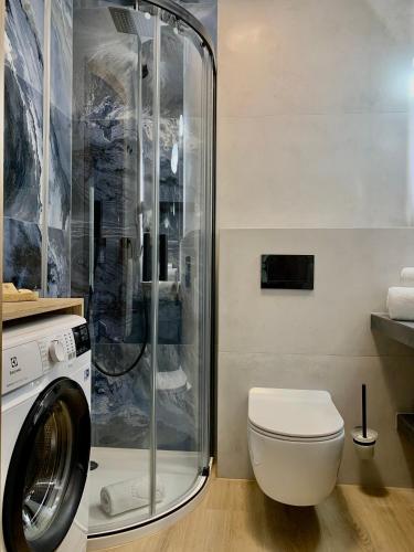 a bathroom with a washing machine and a toilet at REMAR - Apartamenty z widokiem na Jezioro Biale in Augustów
